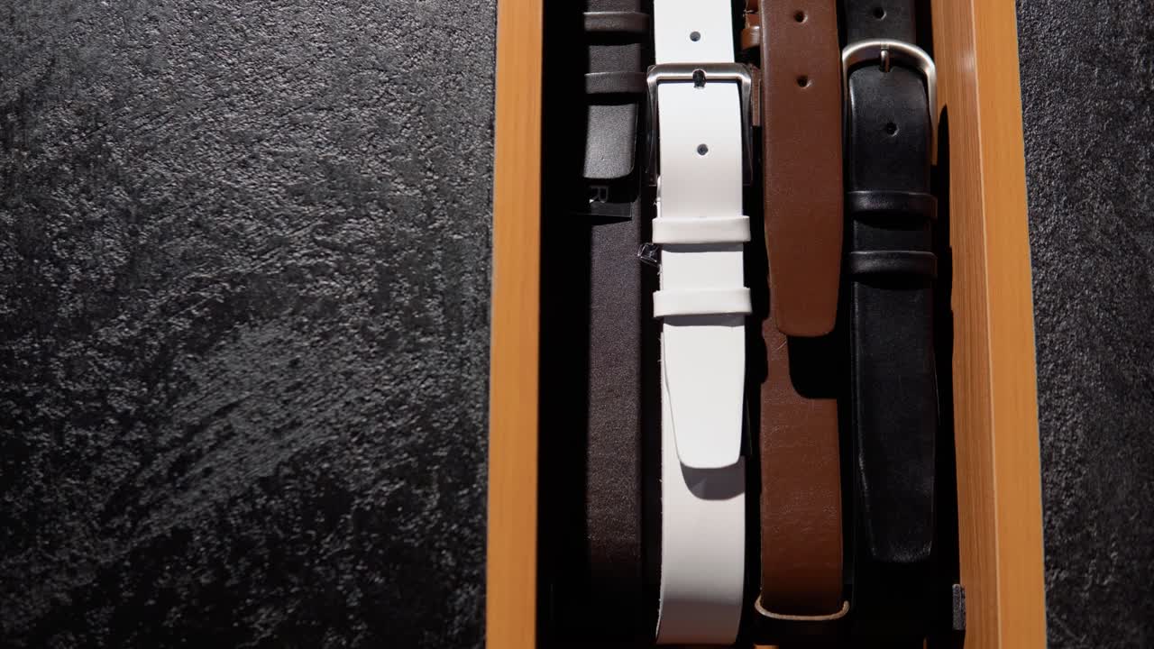 Showcase with belts in luxury boutique of men's clothing and suits