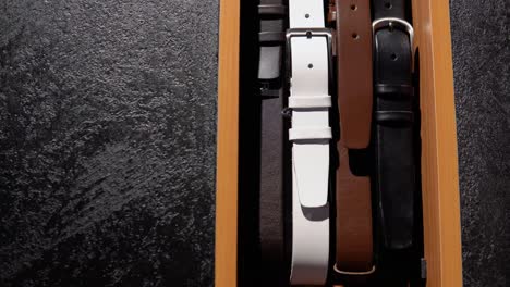 showcase with belts in luxury boutique of men's clothing and suits