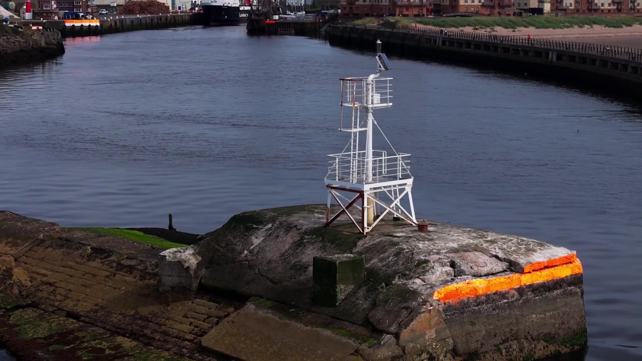 Flyfoto, lite navigasjonsfyr på havneveggen ved Ayr Harbour, Skottland, som markerer kanten av vannveien i den fungerende havnen