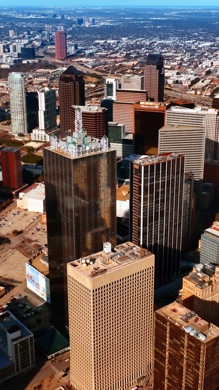 Grattacieli imponenti nel centro di Dallas, Texas, USA. Panorama illuminato dal sole della metropoli dall'alto. Video verticale
