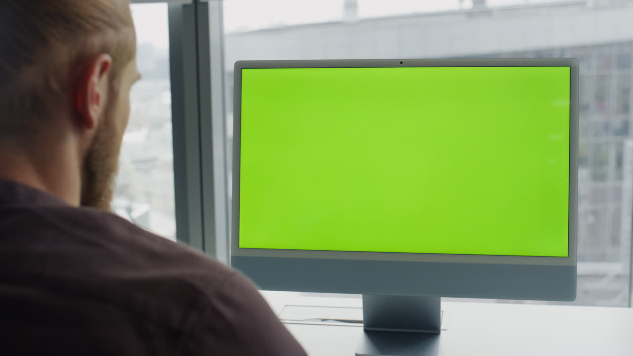 hombre viendo un modelo de lugar de trabajo de computadora. freelancer leyendo un monitor de pantalla verde