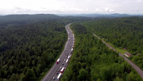 Tráfico-Intenso-En-La-Autopista-Europea-Con-Dos-Líneas-De-Vehículos-Que-Forman-Un-Carril-De-Emergencia-Para-Ambulancias-Y-Socorristas-Que-Consisten-En-Automóviles,-Camiones-Y-Vehículos-Recreativos-Con-La-Vía-Férrea-Cercana