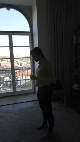 woman practicing yoga by the window