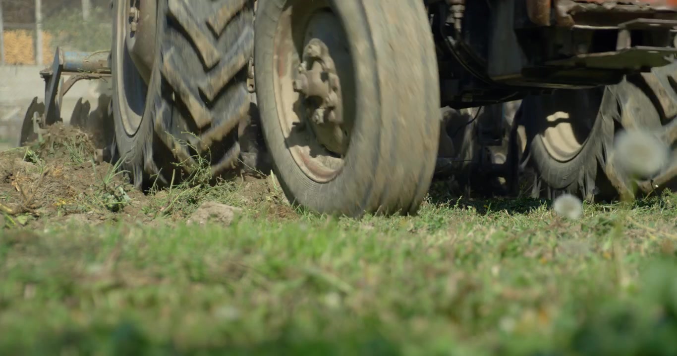 low-angle shot of a farmer using a tractor to plow his field