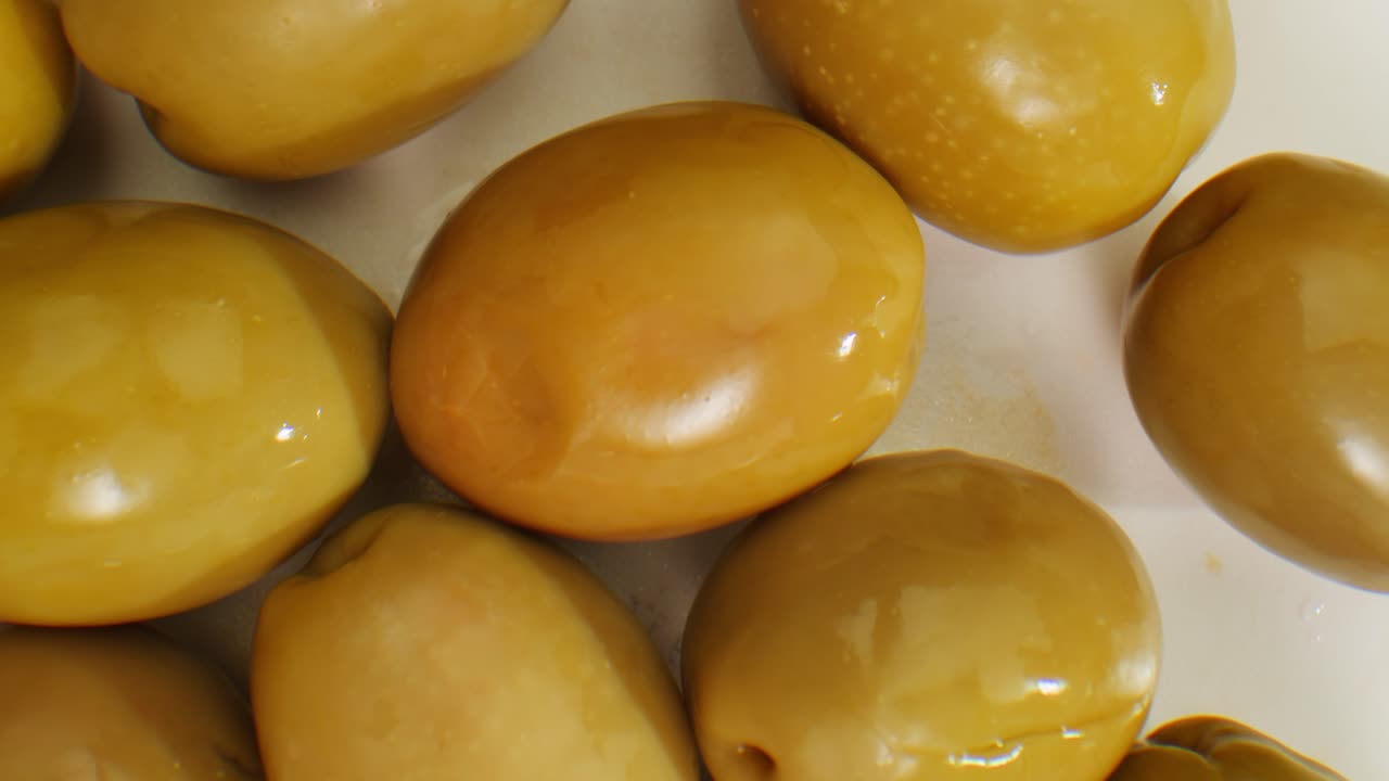 aceitunas verdes redondas en vinagre de grecia como fondo, vista de arriba. imágenes de alta calidad en 4k