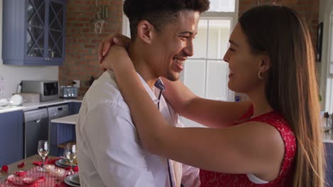 feliz pareja biracial celebrando el día de san valentín bailando juntos en casa