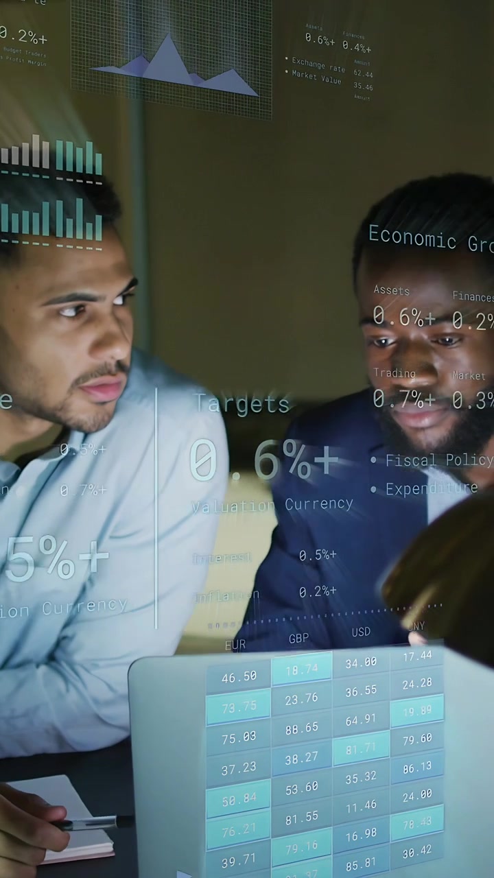 Vertical video: Two men sitting at laptop, overlay appearing and marking financial data to review
