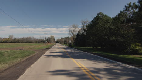 driving straight on a flat road in a typical american agricultural region. driver's view