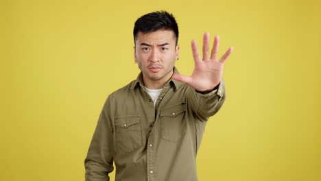 man making a stop gesture with a serious expression