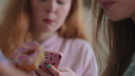 cerca de una adolescente que usa un teléfono inteligente navegando por las redes sociales enviando mensajes de texto a amigos saliendo a comer rosquillas