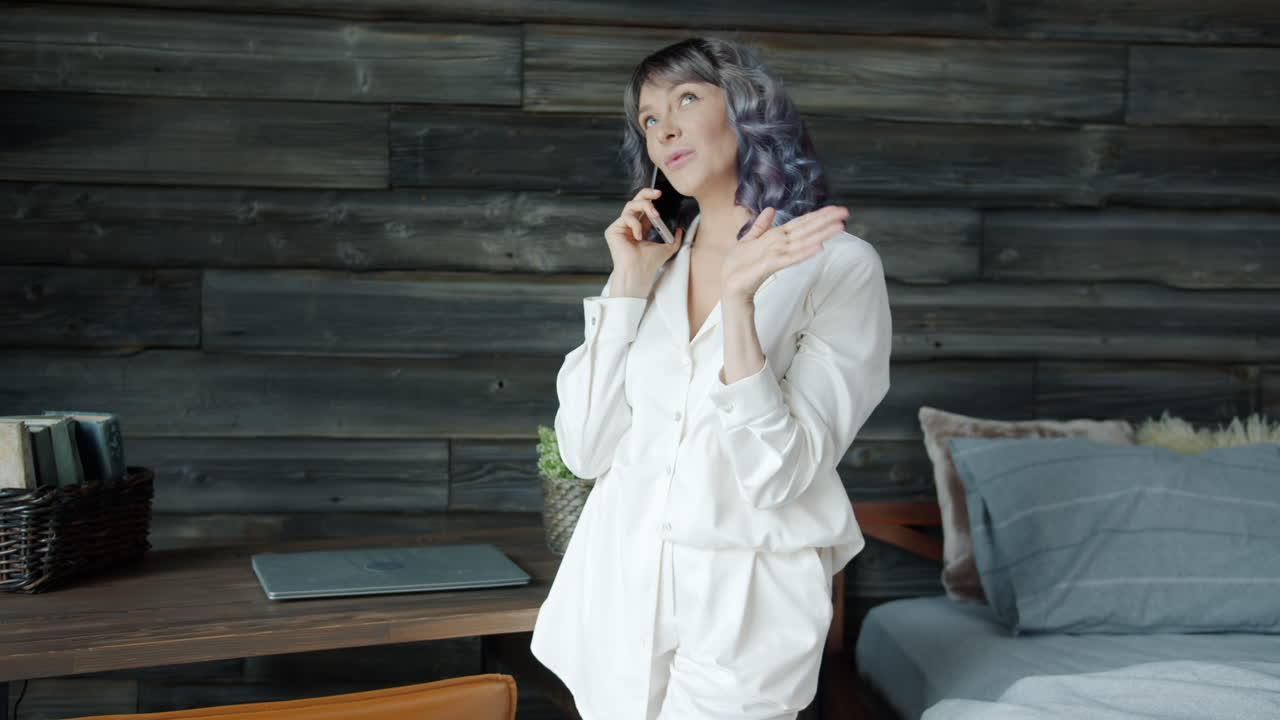 침실에서 전화로 얘기하는 여자