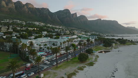 Luxuriöses-Tropisches-Touristenresort-Am-Sandstrand-An-Der-Meeresküste.-Urlaubsziel-Unter-Felsigen-Bergrücken-In-Der-Dämmerung.-Kapstadt,-Süd-Afrika