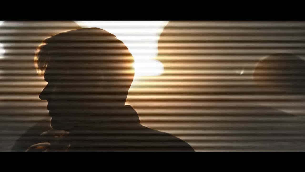 Rising sun behind man silhouette casting lens flare on barren hills with rock spheres, copy space