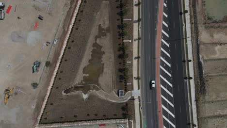 Aerial-view-of-a-large-construction-site-next-to-a-newly-built-main-road