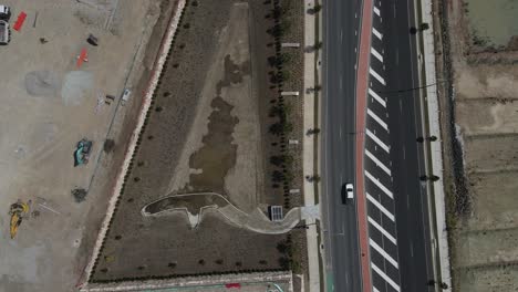 aerial view of a large construction site next to a newly built main road