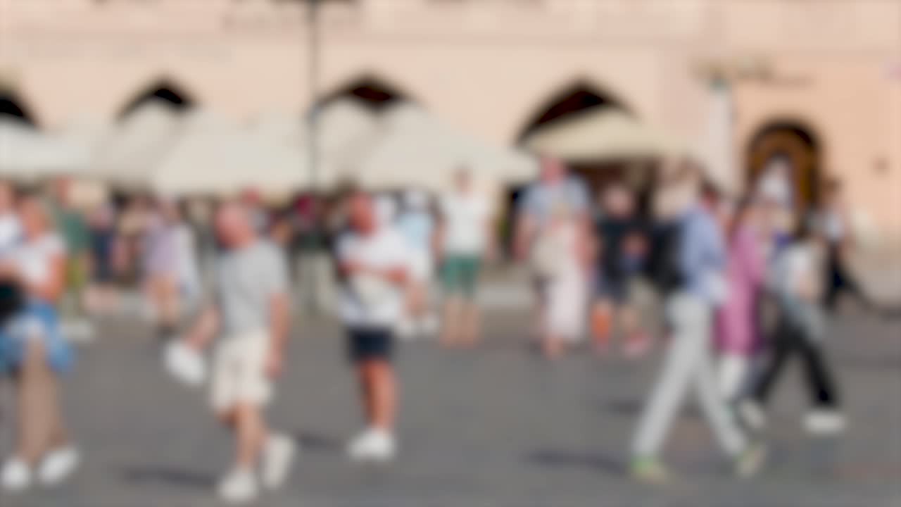 Pedoni fuori fuoco camminano in una piazza storica soleggiata con effetto mosso e bokeh
