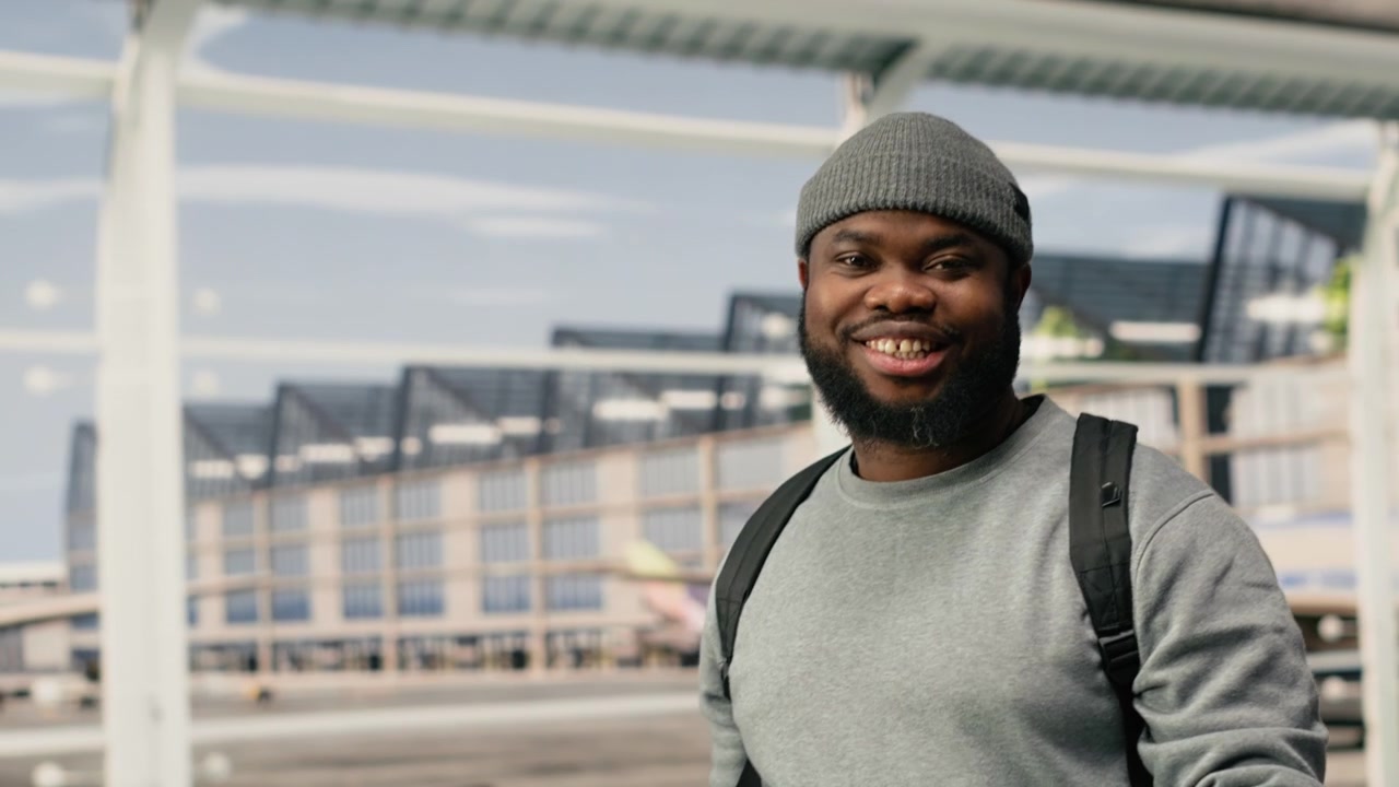 Nærbillede af glad mand i lufthavnen, der glæder sig til ferieturen.