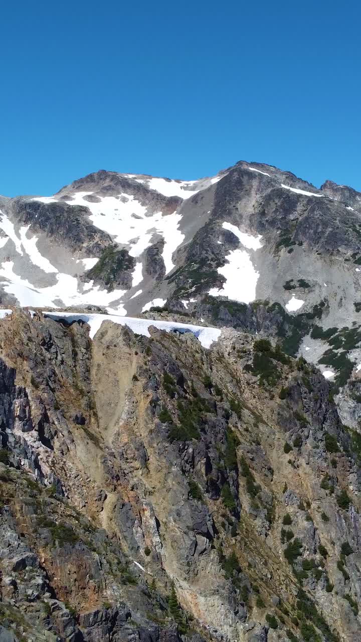 Catena montuosa canadese con effetto parallasse di movimento in primo piano e sfondo, con cielo azzurro chiaro. Ideale per storie sui social media, ispirazione di viaggio. Video verticale formato 9:16.