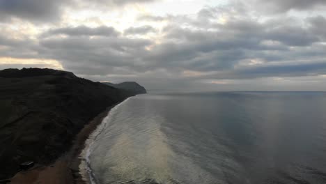 aerial view of cliffs along charmouth beach with morning clouds