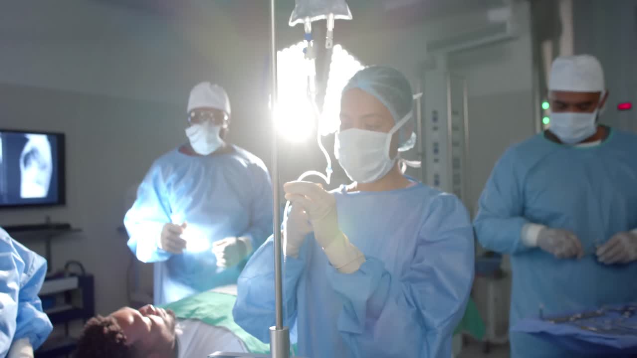 diversos cirujanos masculinos y femeninos con batas quirúrgicas, preparando al paciente para la cirugía, cámara lenta