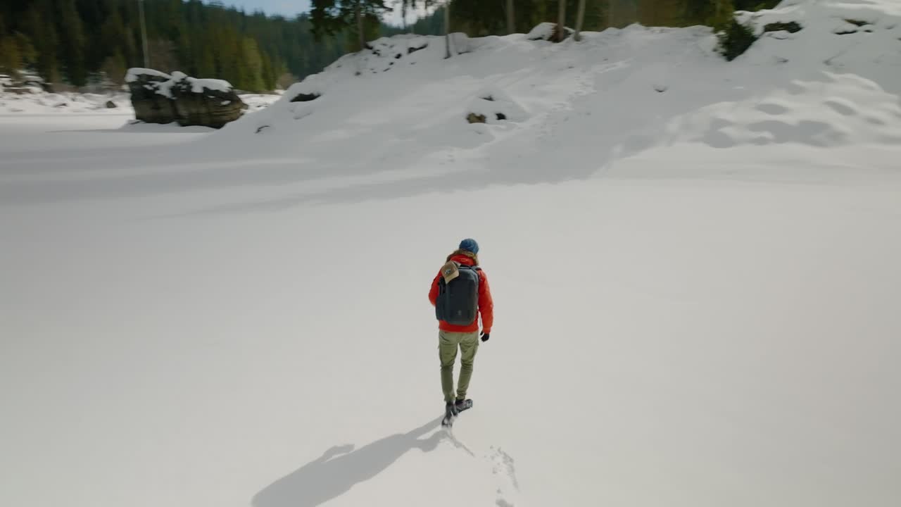 siguiendo a un hombre en mochila caminando cerca del lago caumasee durante el invierno en suiza