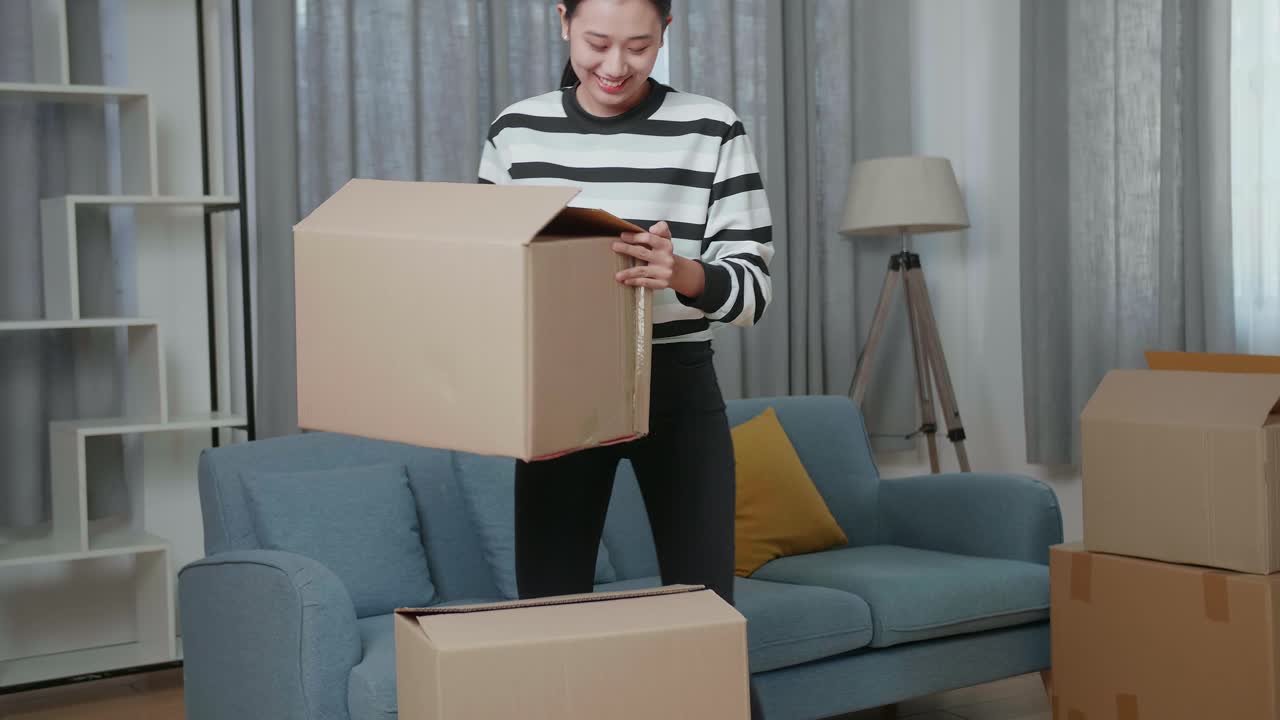 mujer emocionada desempaquetando cajas