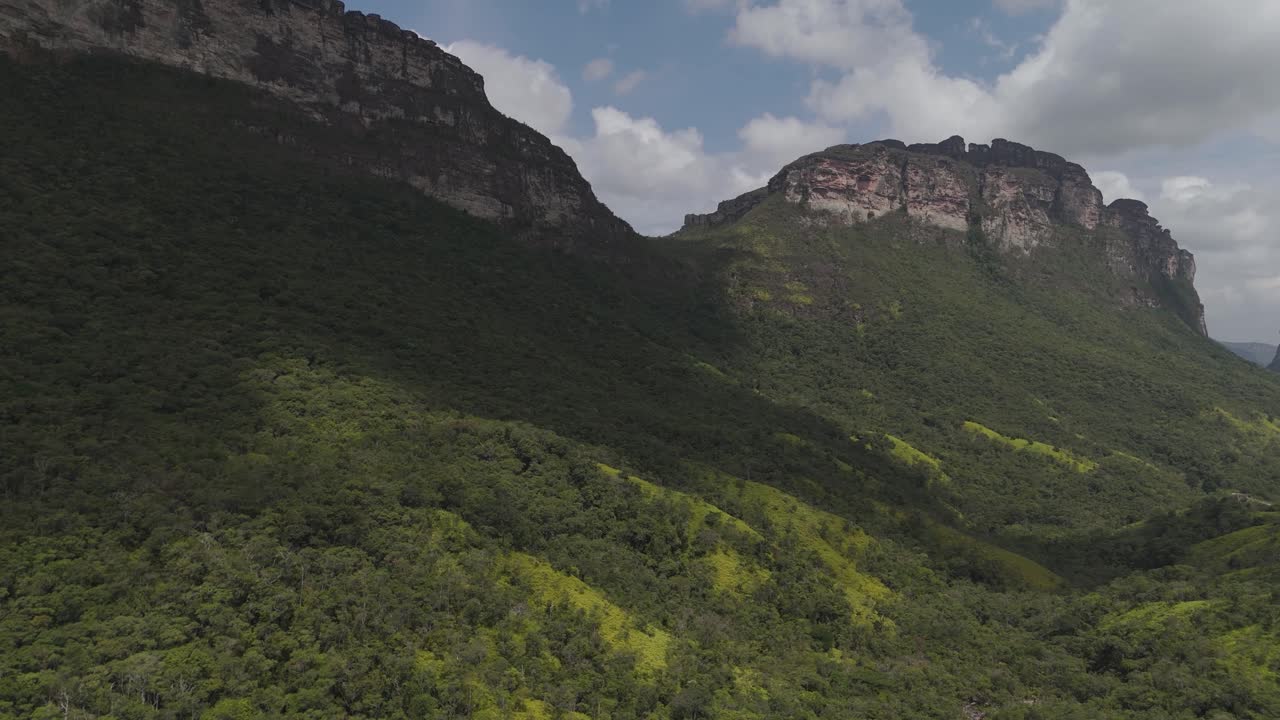A drone shot through Chapada Diamantina National Park overlooking the valley and mountains on a sunny day.