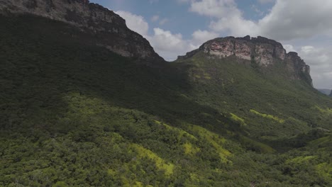 a drone shot through chapada diamantina national park overlooking the valley and mountains on a sunny day.