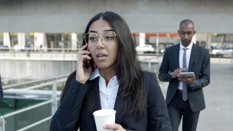 Young-businesswoman-talking-by-cell-phone-on-street