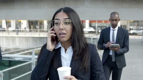 young businesswoman talking by cell phone on street