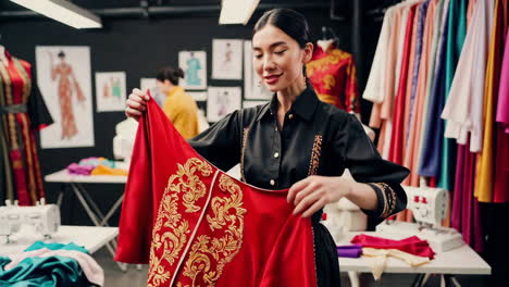 fashion designer working on a traditional embroidered garment in her studio