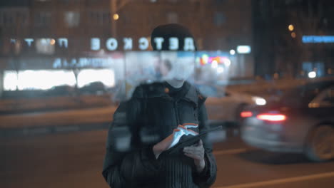 Mujer-Joven-Navegando-Por-Internet-En-La-Plataforma-Mientras-Espera-El-Autobús-En-La-Ciudad-De-Noche