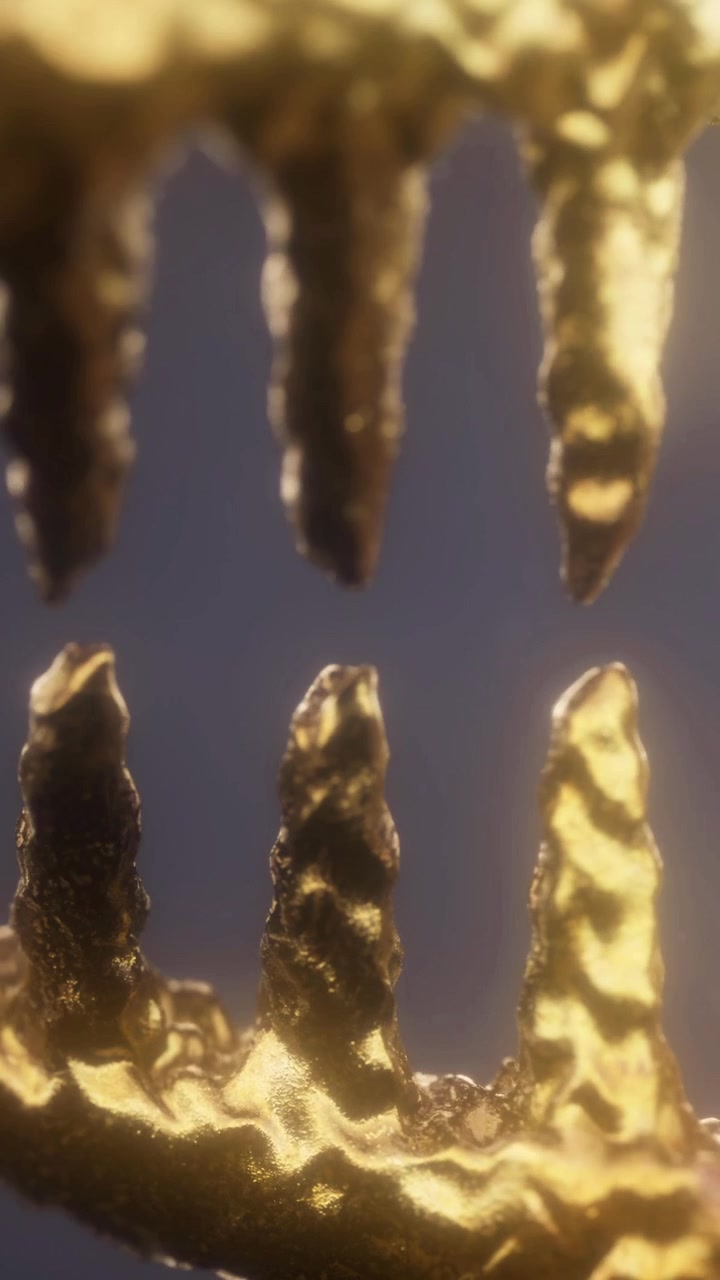 Manufatto dorato che riflette la luce su sfondo scuro, in primo piano.