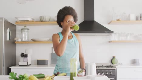 Glückliche-Afroamerikanische-Frau,-Die-In-Der-Küche-Ein-Gesundes-Getränk-Zubereitet