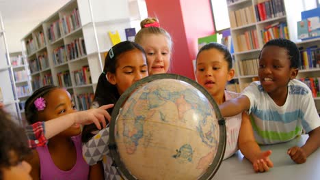 schoolkids looking at globe in the school library 4k