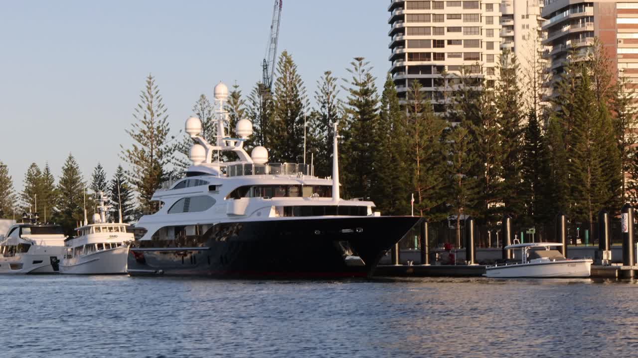 Un grande yacht si muove lungo il lungomare di una città