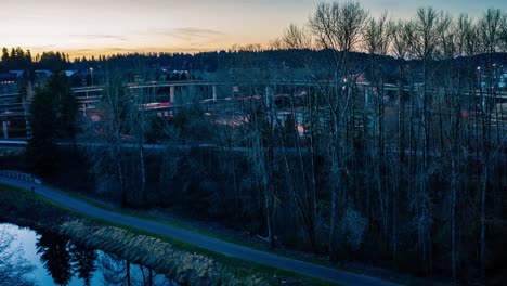 Lufthyperlapse-Eines-Belebten-Und-Interessanten-Autobahnkreuzes-Bei-Sonnenuntergang-Mit-Bergen-Im-Hintergrund