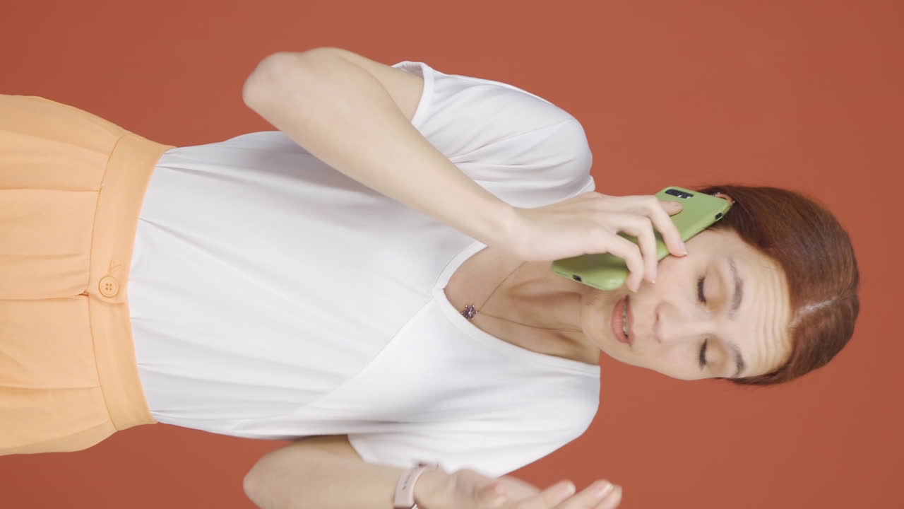 화를 내는 여자가 전화로 이야기하는 수직 비디오.