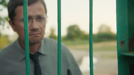 man looking through a fence