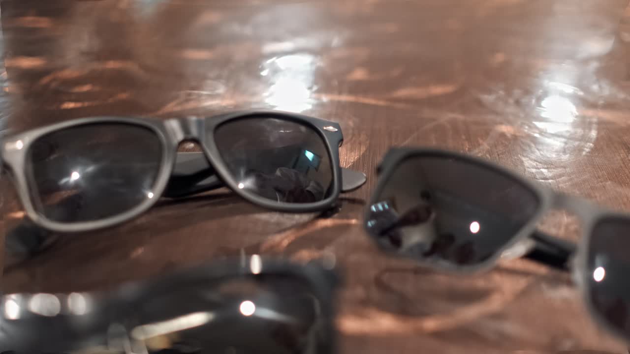 мужчины берут солнцезащитные очки со стола один за другим.