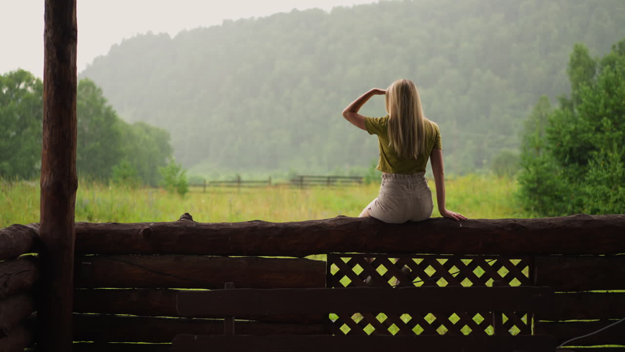 туристка смотрит на далекие горы с еловым лесом.