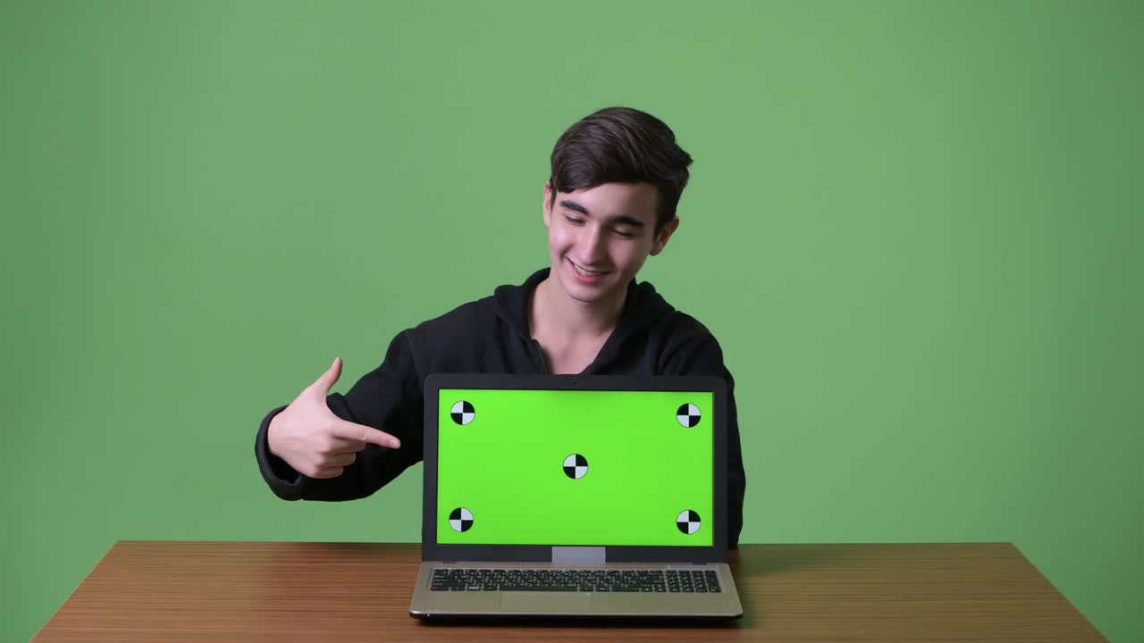 joven y guapo adolescente iraní contra un fondo verde