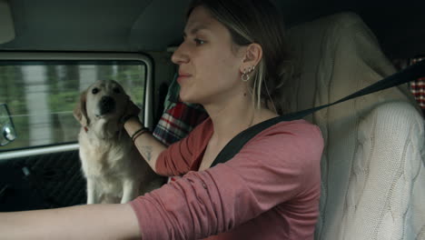 young woman driving van and petting dog