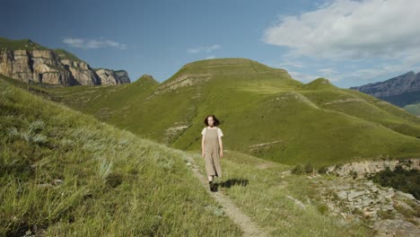 mujer caminando en las montañas verdes