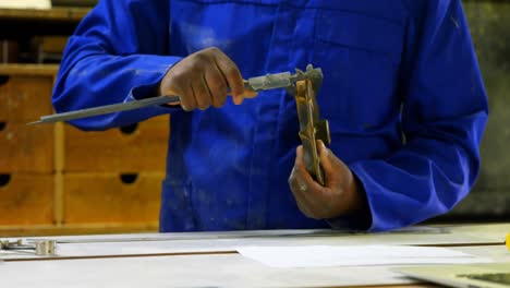 worker working on metal tool in foundry workshop 4k