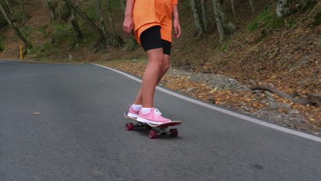 young woman skateboarding on a mountain road