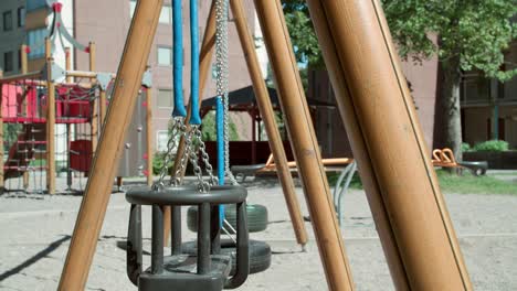 close up of a swing at an empty playground during summer