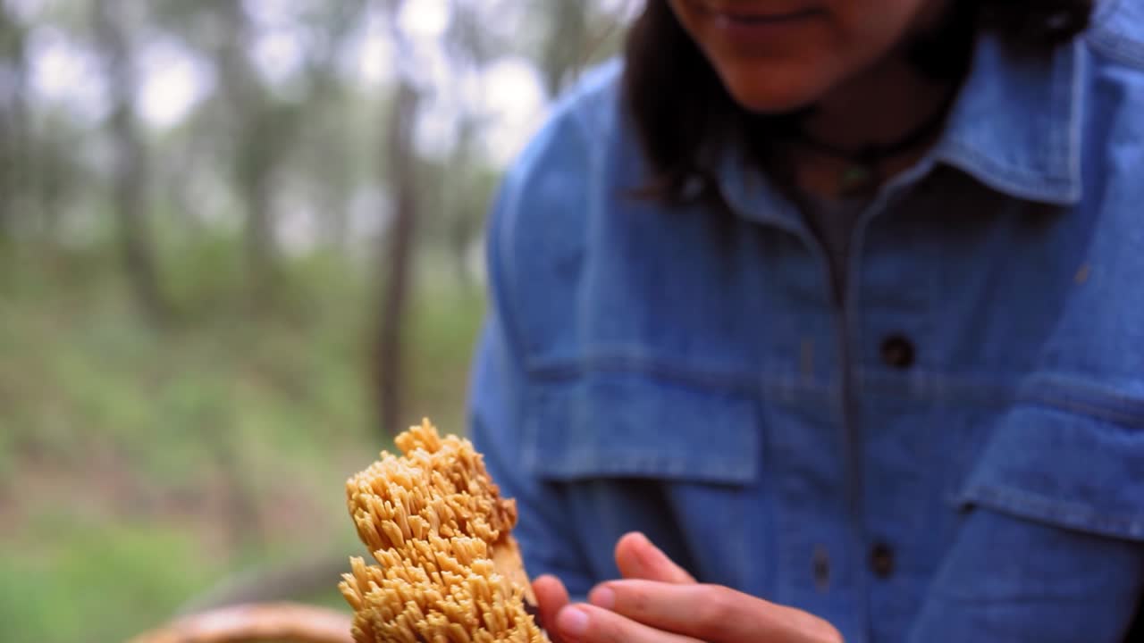 mujer con hongo comestible en las manos en el bosque