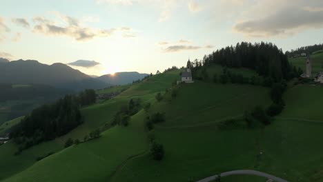 Aerial-cinematic-shot-of-lush-green-hills-in-La-Val-village,-South-Tyrol,-Dolomites,-Italy