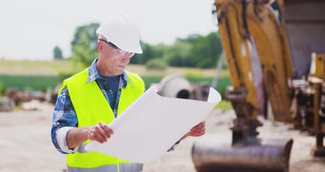 Selbstbewusster-Reifer-Männlicher-Ingenieur,-Der-Blaupause-Analysiert-14